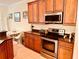 Kitchen featuring wooden cabinets, stainless steel appliances, granite countertops, and adjacent dining area at 184 Banyan Bay Dr, St Petersburg, FL 33705