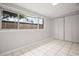 Bedroom featuring a closet and a large window overlooking the backyard with white tiled floor at 1858 Oregon Ave Ne, St Petersburg, FL 33703