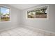 Bright bedroom features white tile flooring and two windows allowing for an abundance of natural light at 1858 Oregon Ave Ne, St Petersburg, FL 33703