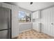 Bright kitchen featuring stainless steel refrigerator, white cabinets, and tile floors at 1858 Oregon Ave Ne, St Petersburg, FL 33703