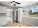 Bright kitchen featuring stainless steel refrigerator, white cabinets, and tile floors at 1858 Oregon Ave Ne, St Petersburg, FL 33703