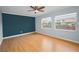 The bedroom features hardwood floors, a ceiling fan, neutral paint, and large windows offering natural light at 1864 Clearbrooke Dr, Clearwater, FL 33760