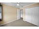 A charming bedroom with neutral paint and carpet, with a closet, ceiling fan, and a doorway leading to another room at 1864 Clearbrooke Dr, Clearwater, FL 33760