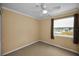 Tan carpeted bedroom with neutral walls, ceiling fan, and window with natural light at 1864 Clearbrooke Dr, Clearwater, FL 33760