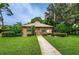 Inviting home featuring a manicured lawn and tidy landscaping, creating great curb appeal at 1864 Clearbrooke Dr, Clearwater, FL 33760