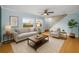 Cozy living room features hardwood floors, large windows, comfortable seating, and an open staircase at 1864 Clearbrooke Dr, Clearwater, FL 33760