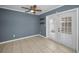 Small empty living room featuring tiled floors, neutral paint, a ceiling fan, and direct access to the backyard at 1864 Clearbrooke Dr, Clearwater, FL 33760