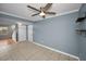 Small empty living room featuring tiled floors, neutral paint, a ceiling fan, and storage closets at 1864 Clearbrooke Dr, Clearwater, FL 33760