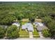 Aerial view of the home highlighting a spacious backyard, adjacent pool, and proximity to lush greenery at 1891 Harmony Dr, Clearwater, FL 33756