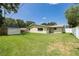 Spacious backyard with a well-maintained lawn, shed, and privacy fencing, perfect for outdoor activities at 1891 Harmony Dr, Clearwater, FL 33756