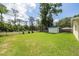 Expansive backyard featuring lush green grass, a storage shed, and a secure fence at 1891 Harmony Dr, Clearwater, FL 33756