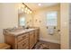 Well-lit bathroom with vanity, storage, decorative mirror and natural light from a window at 1891 Harmony Dr, Clearwater, FL 33756