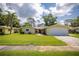 Charming single-story home with manicured lawn, an American flag, and a spacious two-car garage at 1891 Harmony Dr, Clearwater, FL 33756