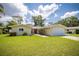 Charming single-story home with a well-maintained lawn, an American flag, and a welcoming red front door at 1891 Harmony Dr, Clearwater, FL 33756