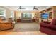 Cozy living room with comfortable seating, a large window, ceiling fans, and a built-in entertainment center at 1891 Harmony Dr, Clearwater, FL 33756