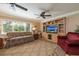 Comfortable living room with a large window, ceiling fans, built-in shelving, and cozy armchairs on top of patterned rug at 1891 Harmony Dr, Clearwater, FL 33756