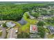 Scenic aerial view of the home surrounded by lush trees and a tranquil lake in the neighborhood at 1902 Hanson Ct # 308, Sun City Center, FL 33573