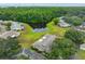 Lush trees surround the community pond in this scenic aerial view at 1902 Hanson Ct # 308, Sun City Center, FL 33573