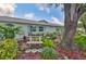 Charming home exterior featuring a lush landscaped yard, mature trees, and a bench in the front garden at 1902 Hanson Ct # 308, Sun City Center, FL 33573