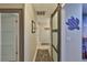 Hallway featuring decorative turtle art and a sliding frosted glass door at 1902 Hanson Ct # 308, Sun City Center, FL 33573