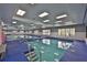 Bright indoor pool area features ample natural light, modern lighting fixtures, and easy access steps for residents' enjoyment at 1902 Hanson Ct # 308, Sun City Center, FL 33573