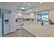 Bright kitchen boasts white cabinets, modern appliances, and granite counters at 1902 Hanson Ct # 308, Sun City Center, FL 33573