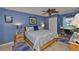 Comfortable main bedroom with wood furnishings, accent wall, ceiling fan, and lots of natural light at 1902 Hanson Ct # 308, Sun City Center, FL 33573