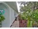 A view along the side of the home which features mature landscaping, trees, and a stone walkway at 1902 Hanson Ct # 308, Sun City Center, FL 33573