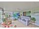 A large sun room with tile floor, ceiling fan, comfortable furniture, and decor accents at 1902 Hanson Ct # 308, Sun City Center, FL 33573