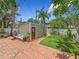 Beautiful backyard featuring a brick patio, artificial grass, tropical plants, and outdoor seating at 231 15Th Ne Ave, St Petersburg, FL 33704