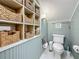 Charming bathroom featuring paneled walls, hexagon tile floors, and storage cubbies filled with decorative baskets at 231 15Th Ne Ave, St Petersburg, FL 33704