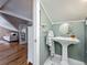 Unique bathroom with pedestal sink, paneled walls, hardwood floors, and access to a comfortable seating area at 231 15Th Ne Ave, St Petersburg, FL 33704