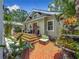 Charming home exterior with brick patio, outdoor seating, and lush tropical landscaping at 231 15Th Ne Ave, St Petersburg, FL 33704