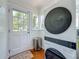 Bright laundry area boasts a stacked washer and dryer set, a door to the outside, and wood floors at 231 15Th Ne Ave, St Petersburg, FL 33704
