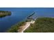 Aerial view featuring a waterfront pier with surrounding wooded area, waters and walking path at 2349 Wood Pointe Dr, Holiday, FL 34691