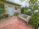 Patio with brick pavers, a bench, and lush landscaping, creating a peaceful outdoor space at 2349 Wood Pointe Dr, Holiday, FL 34691