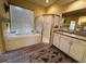 Bathroom featuring a soaking tub, glass shower, and dual sink vanity at 2349 Wood Pointe Dr, Holiday, FL 34691