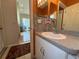 Bathroom vanity with a white sink, grey countertop, decorative mirror, and white cabinets below the sink at 2349 Wood Pointe Dr, Holiday, FL 34691