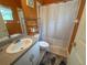 Bathroom featuring a white sink, grey counter, shower with patterned curtain, and orange accent wall at 2349 Wood Pointe Dr, Holiday, FL 34691