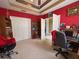 Bedroom with closet, built-in shelves, red walls, tray ceiling and neutral carpet at 2349 Wood Pointe Dr, Holiday, FL 34691