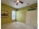 Bedroom featuring light green walls, a ceiling fan, double door closet, and a city picture on the wall at 2349 Wood Pointe Dr, Holiday, FL 34691