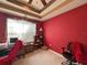 Bedroom with red walls, neutral carpet, ceiling fan and natural light from large window at 2349 Wood Pointe Dr, Holiday, FL 34691