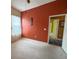 Bedroom featuring light carpet, rust colored wall with African wall art, and open doorway at 2349 Wood Pointe Dr, Holiday, FL 34691