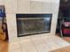 Close up of the fireplace with tile surround and black trim, adjacent to a guitar and shelving unit at 2349 Wood Pointe Dr, Holiday, FL 34691