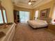 Comfortable main bedroom featuring carpet, tray ceilings, and outdoor access to the pool at 2349 Wood Pointe Dr, Holiday, FL 34691