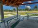 Covered picnic area with green picnic tables, offering a shaded spot for outdoor dining at 2349 Wood Pointe Dr, Holiday, FL 34691