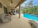 Screened-in lanai features covered patio and pool with beautiful blue water, perfect for relaxation and entertaining at 2349 Wood Pointe Dr, Holiday, FL 34691