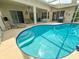 Inviting in-ground pool featuring a unique design with a tanning ledge and steps, perfect for relaxation and outdoor enjoyment at 2349 Wood Pointe Dr, Holiday, FL 34691