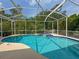Private screened-in pool and spa area with lush landscaping views for recreation and relaxation at 2349 Wood Pointe Dr, Holiday, FL 34691