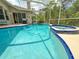 Pool and spa surrounded by screened-in lanai with an outdoor grill, perfect for outdoor living at 2349 Wood Pointe Dr, Holiday, FL 34691